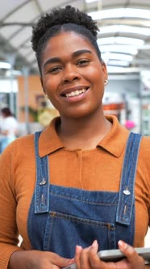 Smiling female employee using tablet in retail store