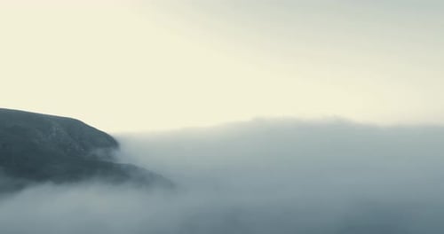 Clouds meet the mountains. A sea of clouds crawl over the ocean in the morning. Earth is beautiful a