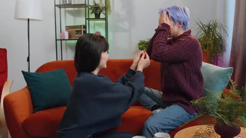Woman Proposes to Partner on Living Room Couch