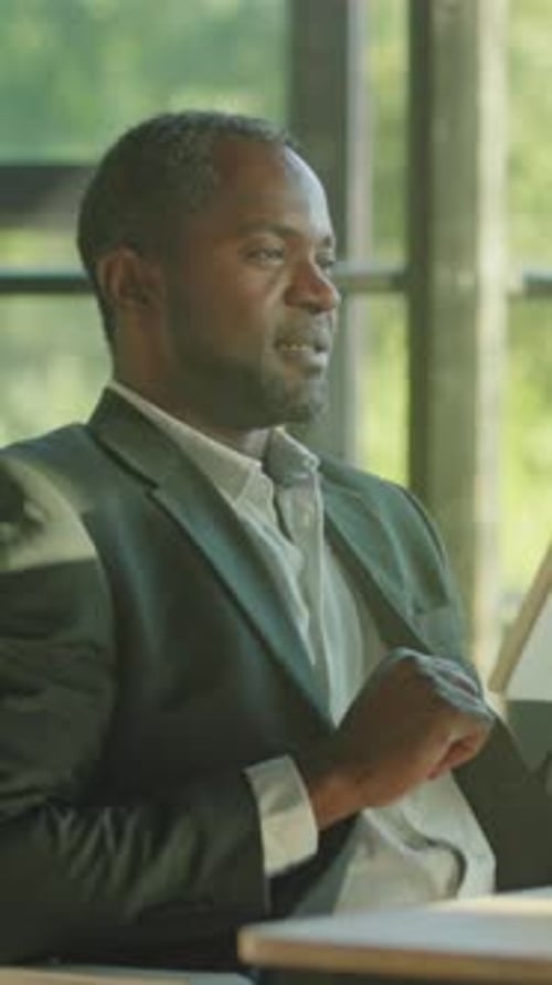 Smiling Man Uses Tablet in Bright Office