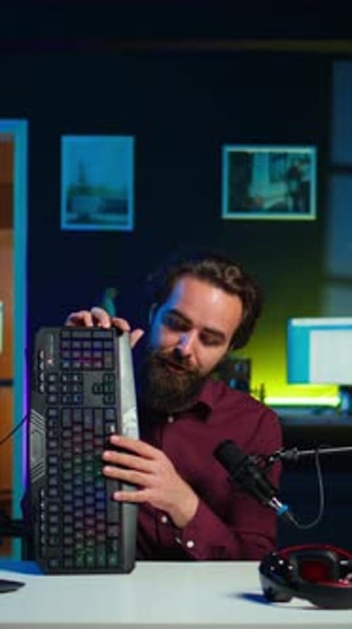 Vertical Video Man in Studio Reviewing Gaming Keyboard Received From Sponsoring Brand