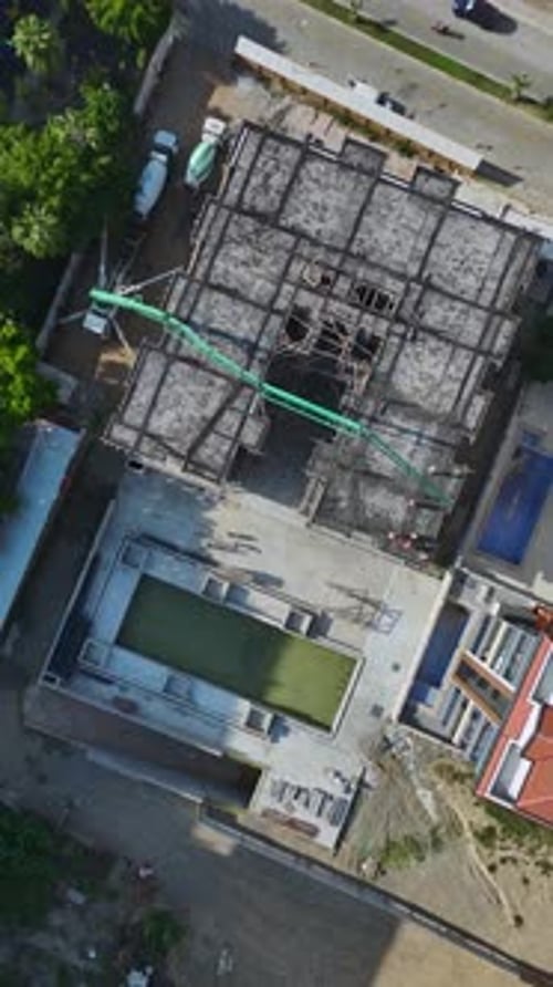 Vertical Video Construction Workers Pouring Concrete and Handling Machinery on a Residential Site