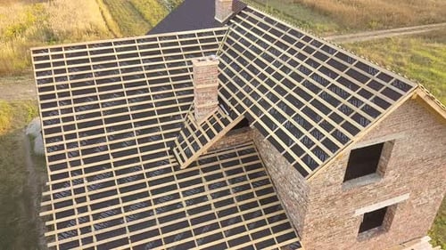 Aerial View of Unfinished House with Wooden Roof Structure Covered with Metal Tile Sheets Under