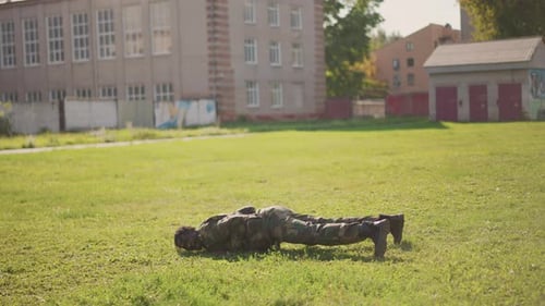 Wide Shot Soldier Performing Continuous Pushups On Grassy Field Camo Uniform Steady Rhythm Urban