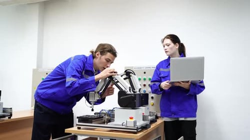 Engenheiros inspecionando e verificando a máquina automatizada de robôs de soldagem de máquinas de armas na fábrica.