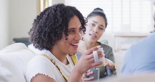 Diverse male and female friends talking and having tea at home in slow motion