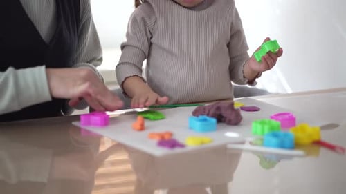 Child and Adult Play Together with Modeling Clay