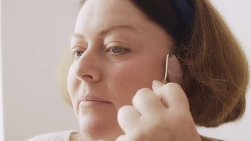 Woman Using Crystal Facial Roller for Skin Care