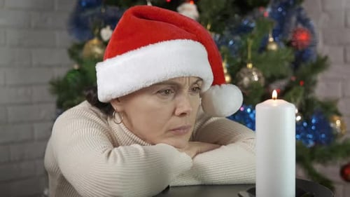 Woman in Santa Hat By Candle Indoor
