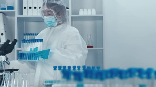 Researcher in Lab with Test Tubes and Microscope