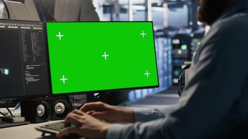 Engineer Using Green Screen Mockup PC in Data Center to Update Servers