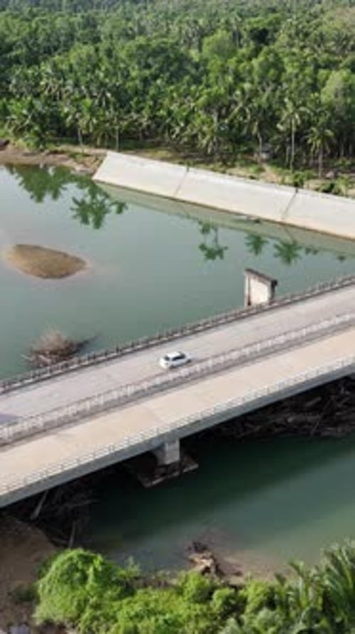 Aerial drone view of a concrete bridge crossing the Loboc River in Bohol, Philippines, surrounded by