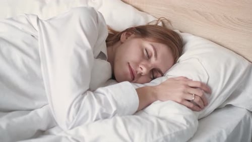 Woman Sleeps Peacefully in Her Cozy Bed