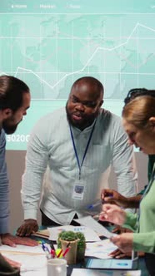 Vertical Video Night Time Meeting Unfolds As a Multiethnic Team Gathers in a Strategy Room