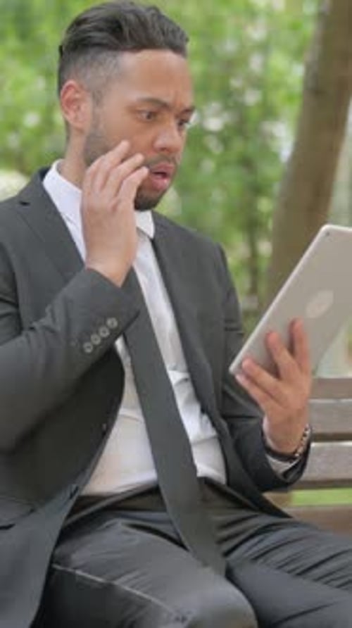 Vertical video, Mixed Race Businessman with Loss on Tablet Outdoor