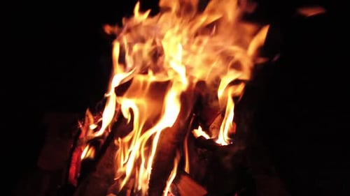 A burning log fire in the night, slow motion capture.