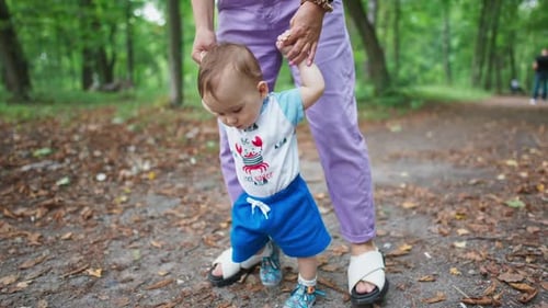 Baby Learning to Walk with Parent in Park