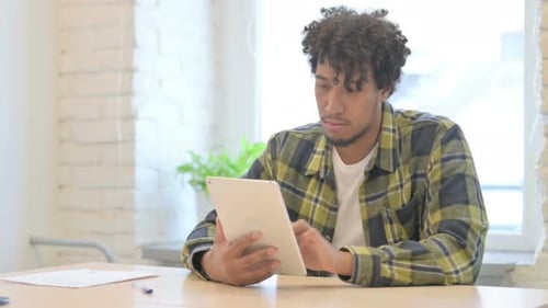 Young Adult Using Tablet at Desk Indoors