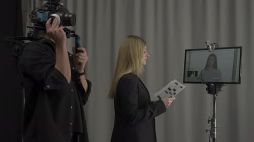 Side View of a Woman Director and Cameraman in the Studio in Front of the Monitor Female Director