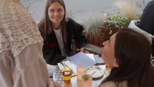 Woman sitting at a table on a summer terrace of a city restaurant with a friend
