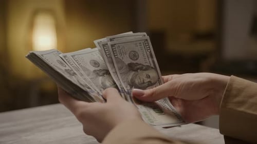 Woman Counting Money with 100 Dollar Bills
