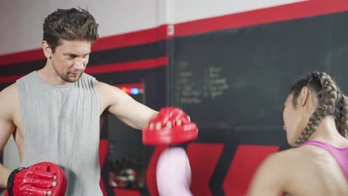 Man and woman practice boxing at the gym.