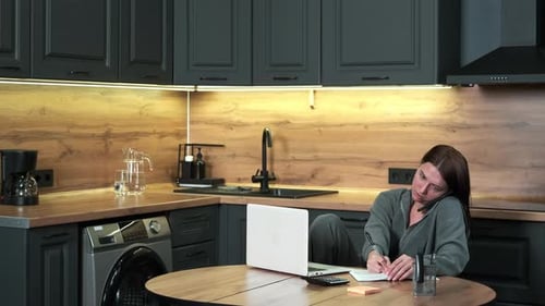 Woman Works At Home at Kitchen Table