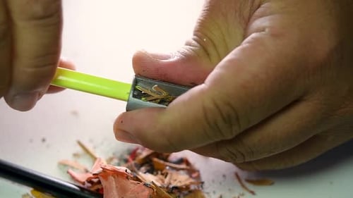 Footage of hands slowly sharpening a pencil and some coloured pencils with a Wedge Pencil Sharpener.