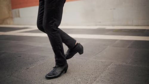 Man in Black Pants Dancing on Urban Sidewalk