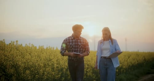 Farmer And Agronomist Discussing In Farm During Sunset