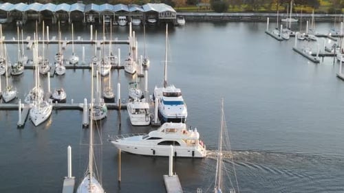 Luxury Yacht Charter Entering Marina With Moored Boats. - aerial