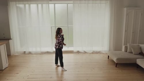 Young Woman Dancing Expressively in Modern Living Room