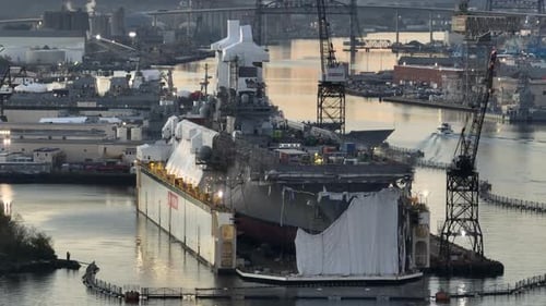 Kriegsschiff im Trockendock einer Marinewerft bei Sonnenaufgang. Startaufnahme der amerikanischen Marine aus der Luft