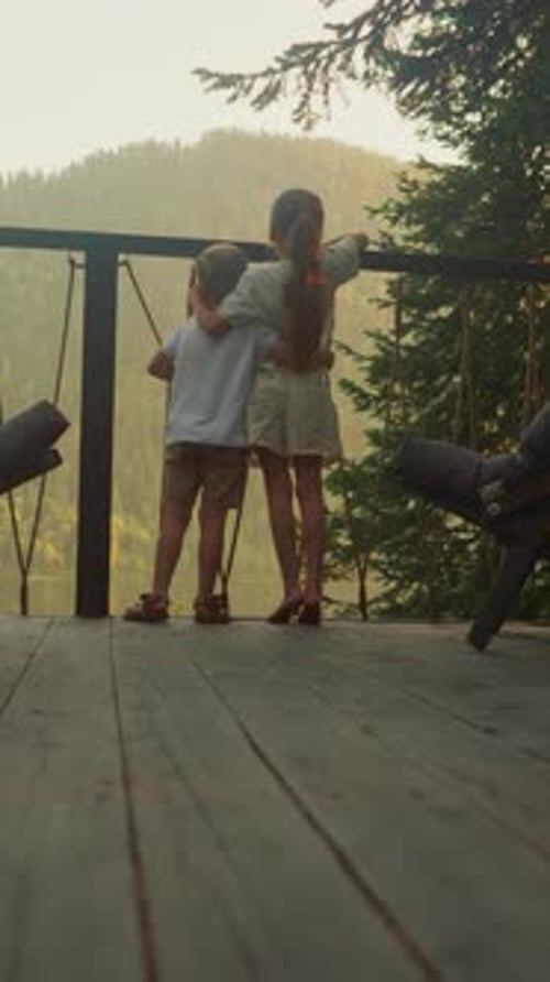 Siblings Look at Forest Hugging Each Other on Terrace