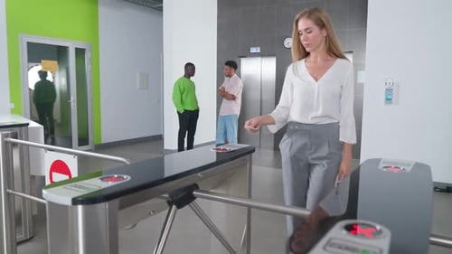 Sistema de pases en la entrada del edificio de oficinas: salida de empresaria por el elevador de torniquetes