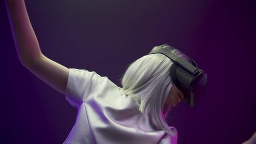 Woman Experiencing Virtual Reality with Controllers and Headset