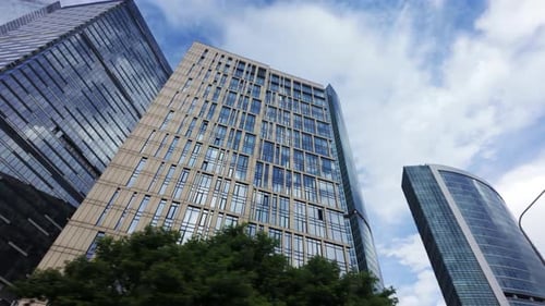 View From Below Showcases Contemporary Towering Glass Skyscrapers Set Against a Backdrop of Cloudy