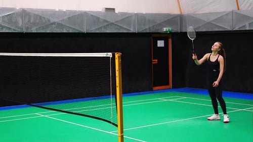 Sports Young Woman with Racket and Shuttlecock is Exercising Playing in Badminton on Inside Court