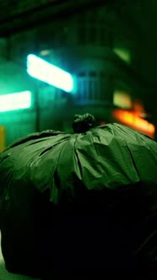 A Garbage Bag Sitting on the Ground in Front of a Building