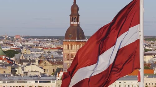 Latvian Flag Waving Over Riga Cityscape