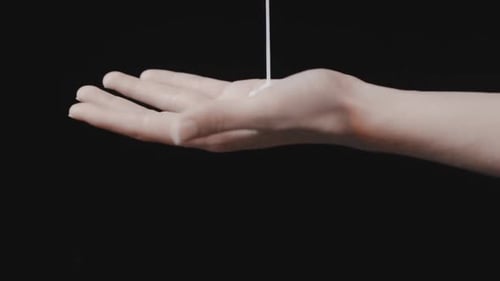 Liquid Being Poured onto a Hand Close Up