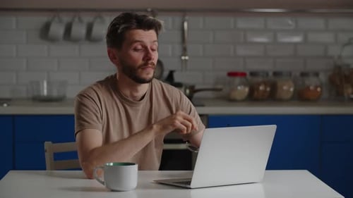 Adult Man Working On Laptop, Rubbing Eyes