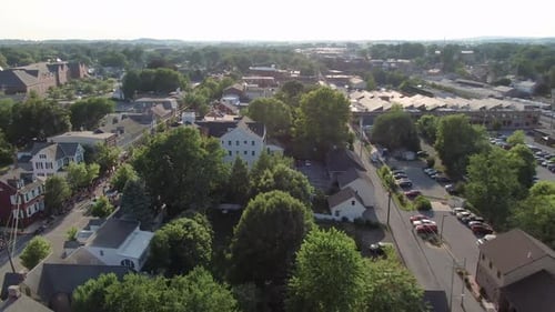 Aerial dolly shot reveals crowds watching parade in restored historic district of American small tow