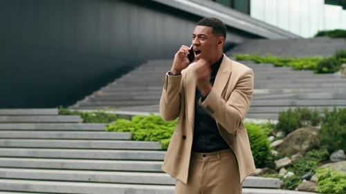 Young Adult Talking on Phone Outside Office Building