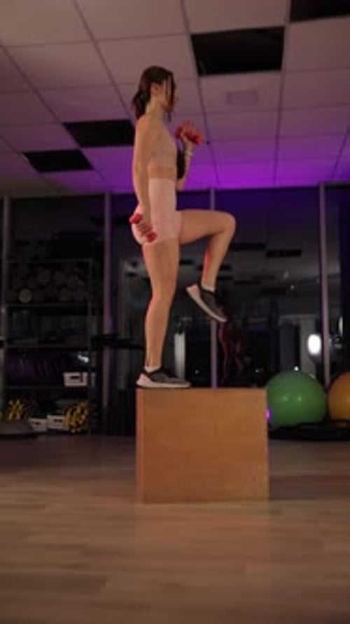 Woman Lifting Dumbbells in a Beautifully Lit Night Studio Vertical Video