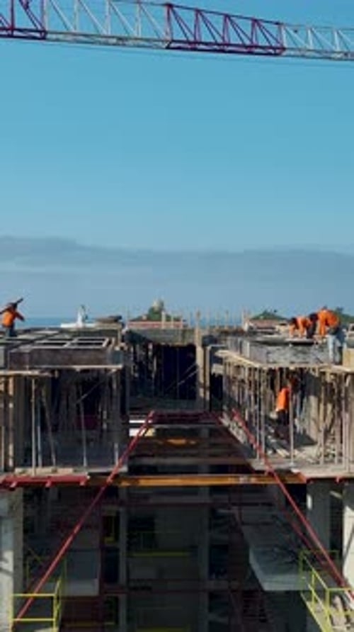 Vertical Video Workers Aligning Panels Within Concrete Framework System