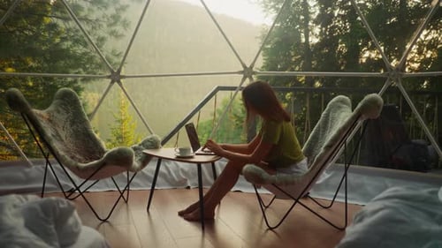 Woman Works on Laptop in Dome Tent at Sunrise
