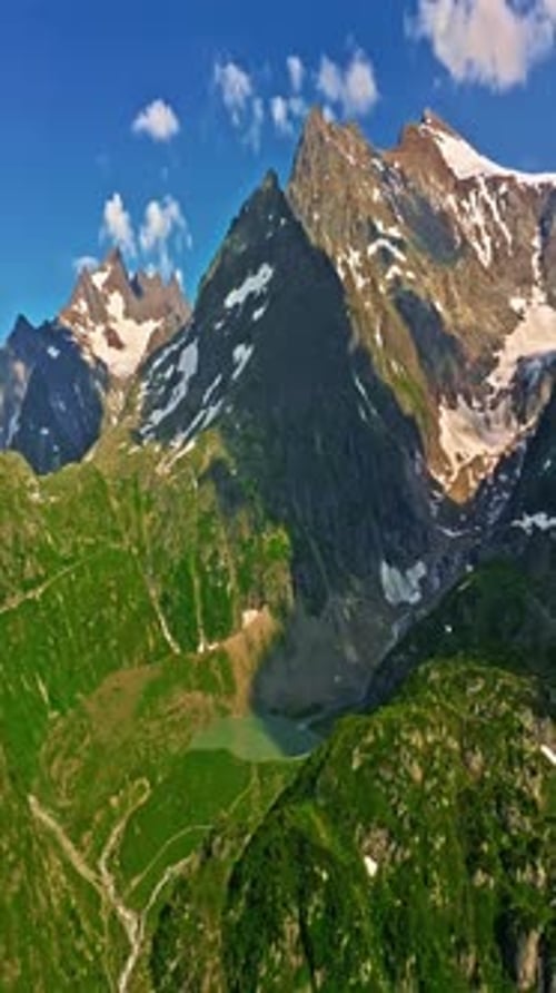 Drone Flies Over Green Picturesque Valley with Mountains in the Background High Mountains Famous