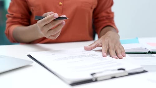 Close up of an african american female hand signing documents at a desk at a workplace in a business