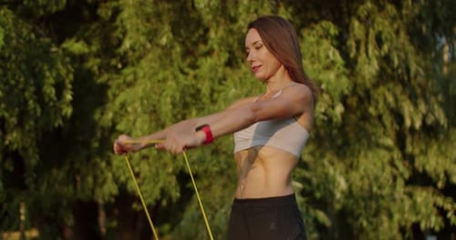 Woman Exercising with Resistance Band in a Park